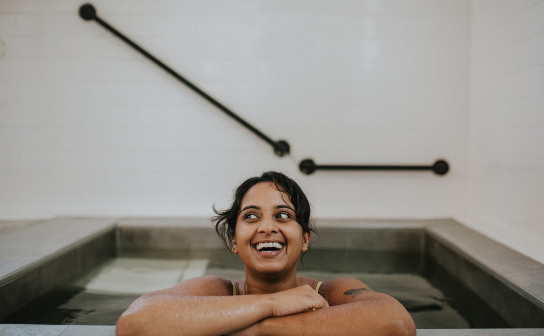 Young woman enjoying a cold plunge at Sauna House Asheville.