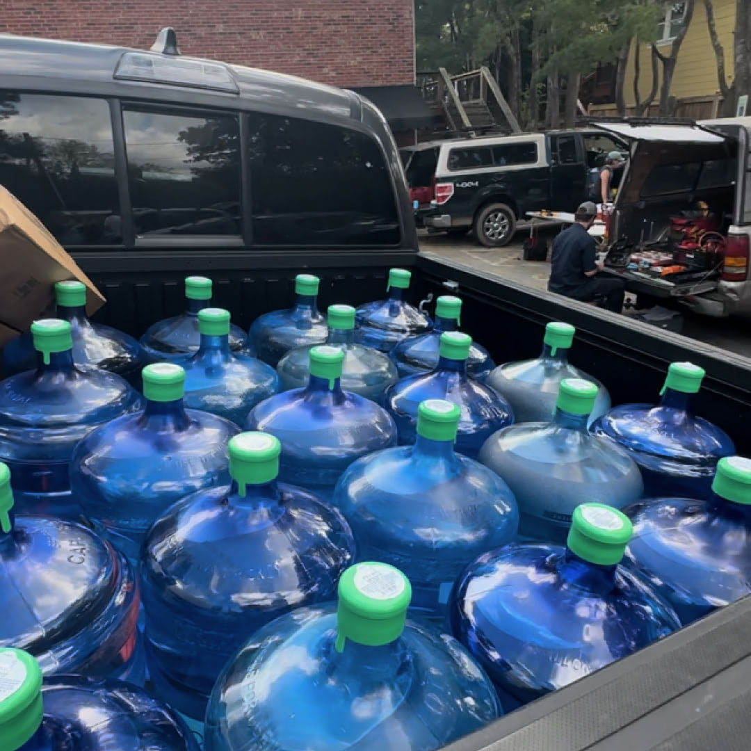 Water jugs loaded into the back of a truck being dropped off in Asheville