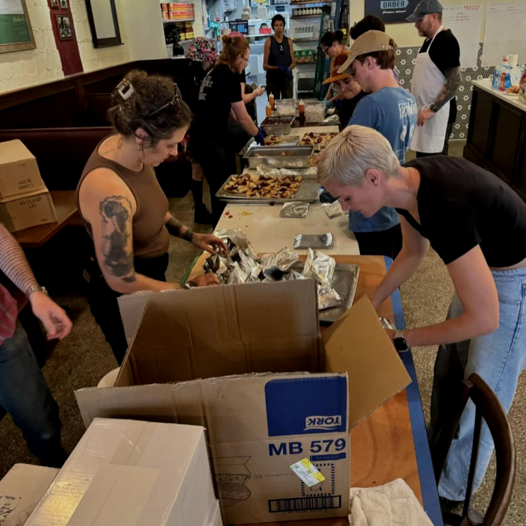 People working in a food prep line with World Central Kitchen packaging meals to be delivered to hard hit communities in WNC.